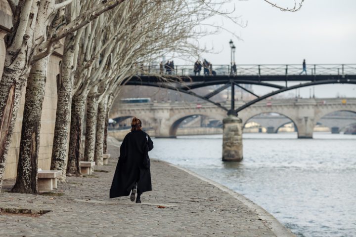 Donna in nero, passeggia lungo la Senna a Parigi