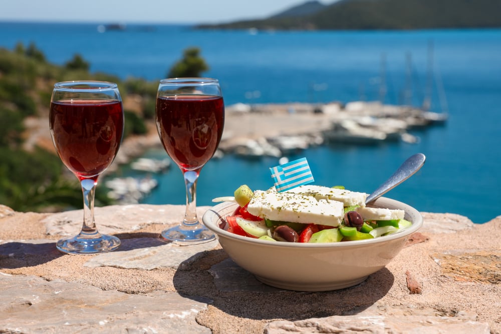 due bicchieri di vino rosso e insalata greca 